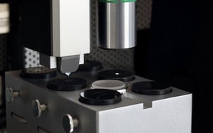 FT-I04 Femto-Indenter positioning its tip above sample holders for precision measurement.